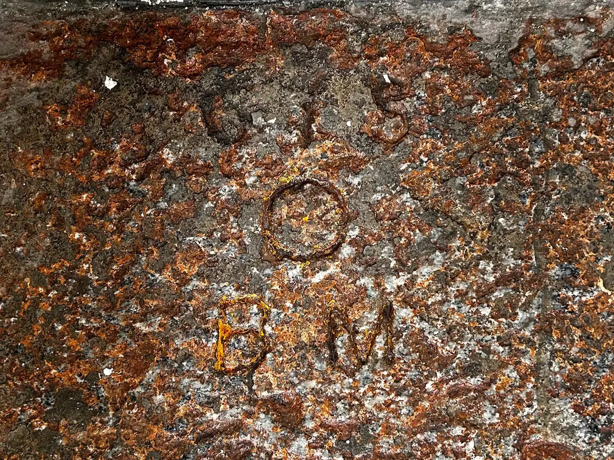 The letters 'BM' carved into the stone steps of the church