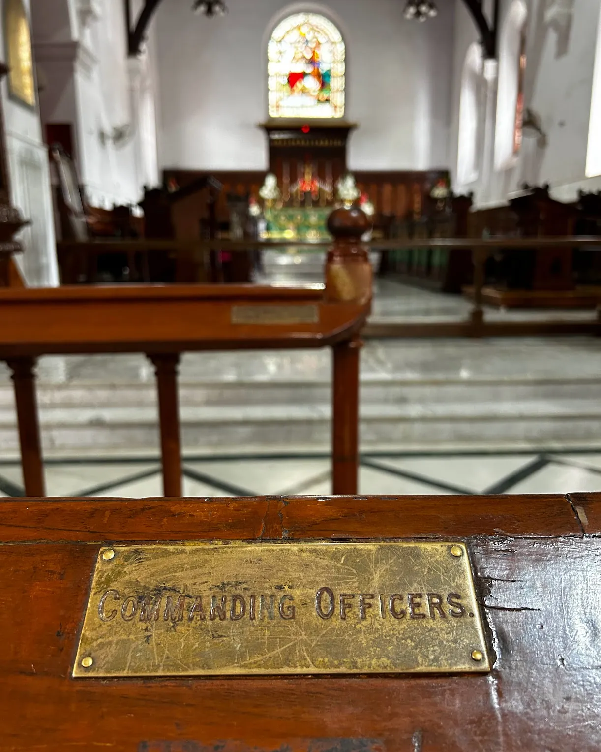 A brass 'Commanding Officers' plaque on a church pew