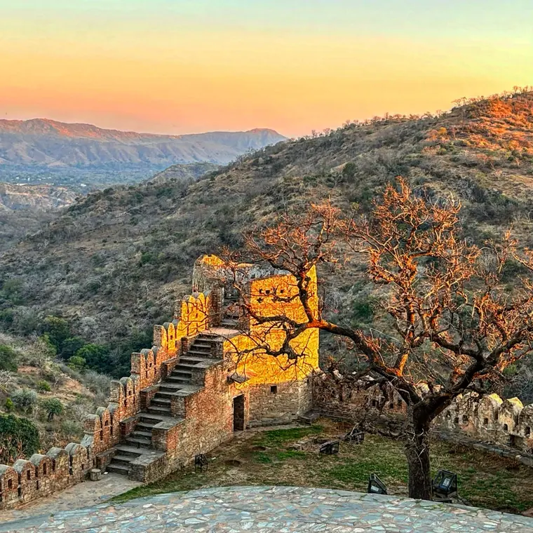 The ramparts of Kumbhalgarh Fort winding over the Aravali hills at sunset